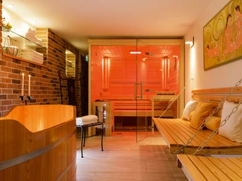 Spa-Bereich Moderner Spa-Bereich mit Sauna, Relaxliegen, Holzmobiliar und sanfter Beleuchtung in warmen Tönen.