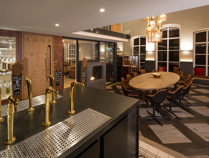 Privat-Brauerei Strate Detmold - Tastery Ein modern gestalteter Verkostungsraum mit edlen Zapfanlagen und stilvoller Möblierung in warmer Atmosphäre.