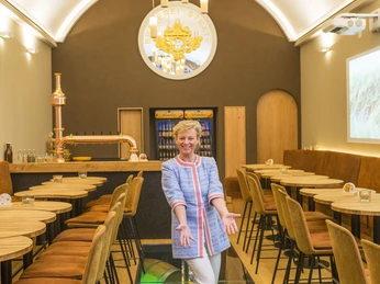 Eine Frau steht in einem modernen, stilvoll eingerichteten Restaurant mit einem Glasboden.