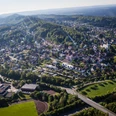 Luftbild Oerlinghausen Luftaufnahme von Oerlinghausen mit grünen Hügeln, dichter Bebauung und umliegenden Wäldern bei Sonnenschein.