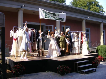 Kultur in der Romantik Bad Rehburg Eine historische Aufführung in Bad Rehburg zeigt Darsteller in romantischer Kleidung auf einer Bühne.