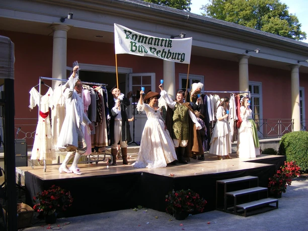 Kultur in der Romantik Bad Rehburg Eine historische Aufführung in Bad Rehburg zeigt Darsteller in romantischer Kleidung auf einer Bühne.
