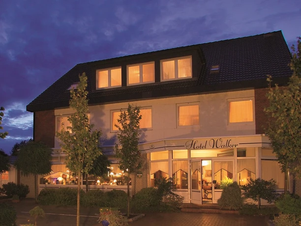 Hotel_Walker-Papenburg-Aussenansicht_mini.jpg Beleuchtete Außenansicht des Hotel Walker in Papenburg bei Abenddämmerung mit klarer Fassade