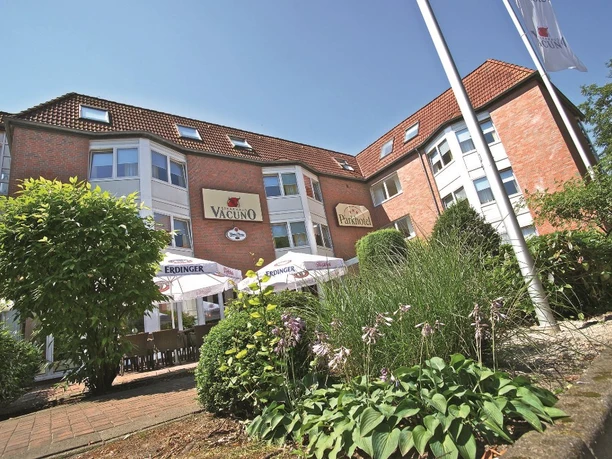 Parkhotel_Papenburg_-_Aussenansicht_mini.jpg Backsteingebäude des Parkhotels Papenburg mit Terrasse, Sonnenschirmen und gepflegter Gartenanlage.