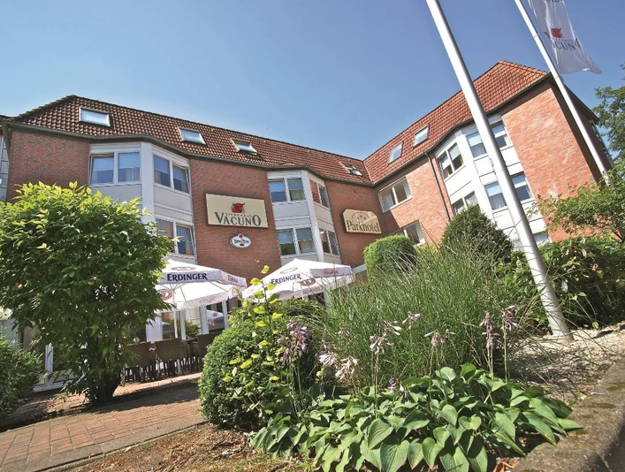 Parkhotel_Papenburg_-_Aussenansicht_mini.jpg Backsteingebäude des Parkhotels Papenburg mit Terrasse, Sonnenschirmen und gepflegter Gartenanlage.