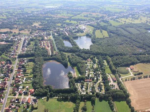 campingplatz-papenburg Luftaufnahme des Campingplatzes Papenburg mit Stellplätzen, Teichen, Grünflächen und Waldareal.
