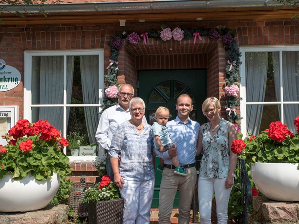 Familie Bergmann Fünfköpfige Familie Bergmann vor dem blumengeschmückten Eingang des Landgasthauses Eichenkrug.