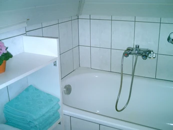 Badewanne mit kleinem Regal daneben