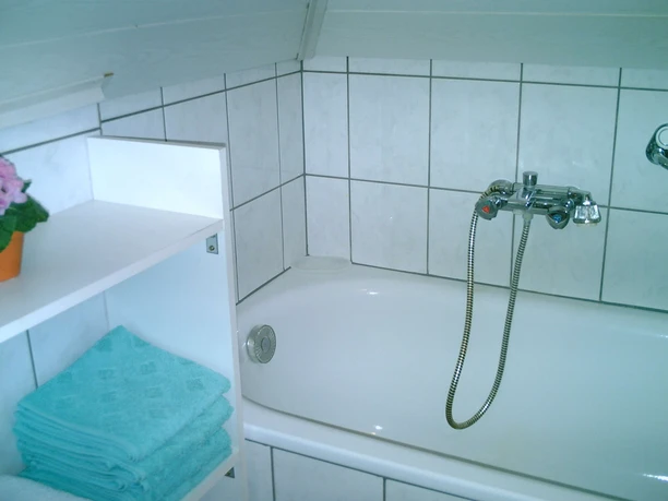 haus-rosen-bad Badewanne mit kleinem Regal daneben