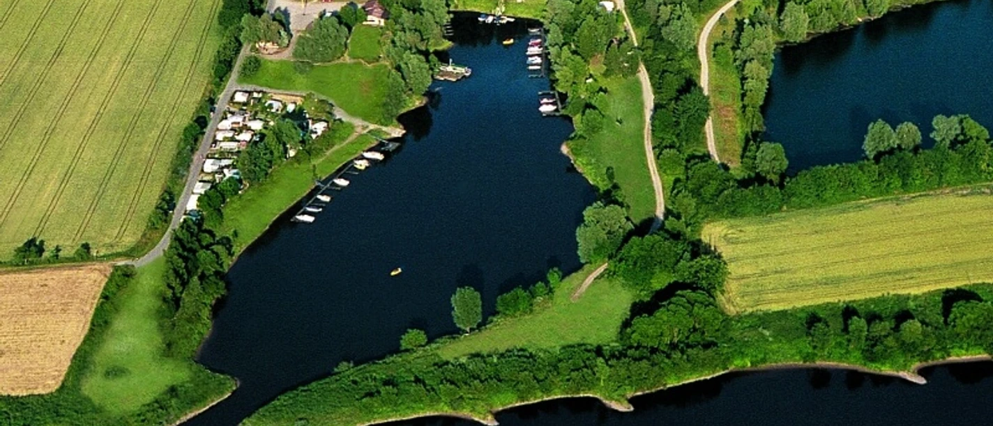 Luftbild eines Yachthafens mit angrenzendem Campingplatz am Treffpunkt dreier Ländergrenzen.