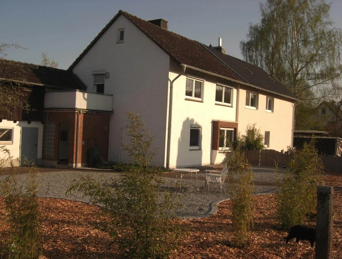Hausansicht mit Kiesfläche und SträuchernHouse view with gravel area and shrubs