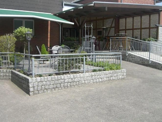 Außenbereich der Gaststätte Ottenhues mit Tischen und Stühlen auf einer Terrasse, umgeben von Geländern.