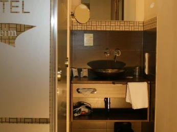 Badezimmer Modernes Badezimmer mit freistehendem Waschbecken, Handtuchhalter und Spiegelbeleuchtung.