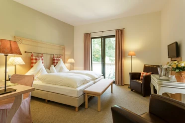 Zimmer im Landgasthof Mücke in Marsberg Geräumiges Landgasthof-Zimmer mit Doppelbett, Schreibtisch, Sesseln und einem großen Fenster mit Blick ins Grüne.