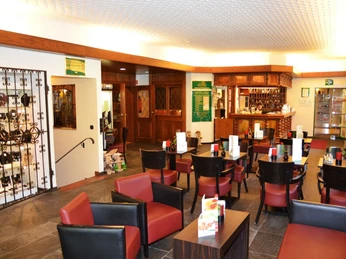 Wohlfühlhotel DER JÄGERHOF Willebadessen - Rezeption Rezeption des Wohlfühlhotels DER JÄGERHOF mit gemütlichen Sitzbereichen und dekorativen Holzdetails.