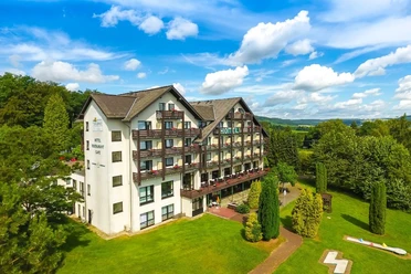 Das Wohlfühlhotel DER JÄGERHOF in Willebadessen ist umgeben von Grünflächen und Bäumen.