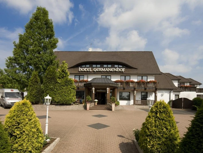 Germanenhof Steinheim-Sandebeck, Außenansicht Das Hotel Germanenhof, ein traditionelles Fachwerkhaus mit begrüntem Vorplatz und einladendem Eingang.