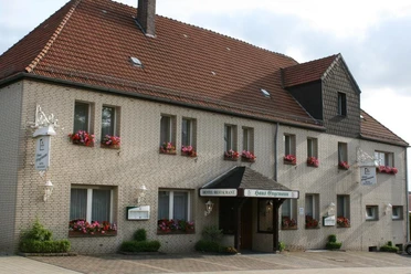 Gasthaus Engemann in Lichtenau mit rotem Ziegeldach, blühenden Blumenkästen und einladender Fassade.