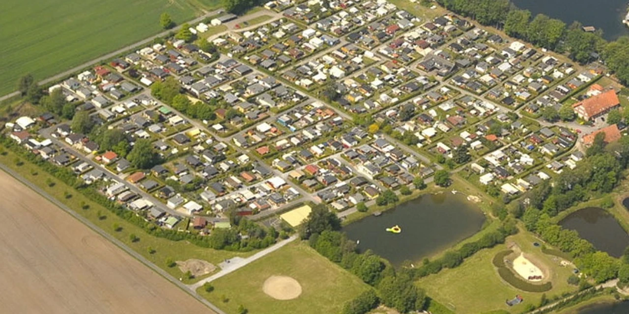 Camp zur Rotbuche Luftaufnahme eines großen Campingplatzes mit Wohnmobilen, umgeben von Wald und zwei kleinen Seen.