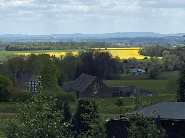 Jugendgästehaus Rödinghausen - Panoramablick auf den Teutoburger Wald Panoramablick über eine weite Landschaft mit Feldern und Wald im Teutoburger Wald, unter blauem Himmel.
