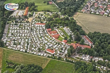 Campotel Bad Rothenfelde Luftaufnahme eines weitläufigen Campingplatzes mit zahlreichen Wohnwagen und umgeben von Wäldern und Feldern.