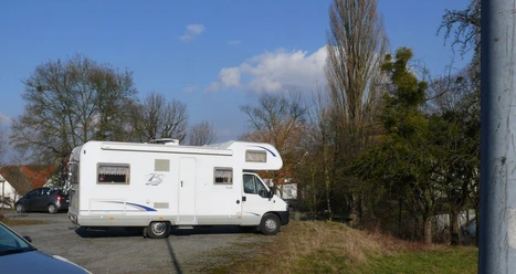 Wohnmobilstellplatz am Klunsberg Nieheim Wohnmobil auf einem Parkplatz am Klunsberg in Nieheim, umgeben von Bäumen und freiem Himmel.