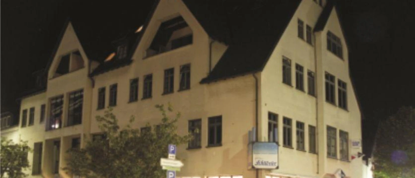 Betten-Paradies & Pension Schübeler Außenansicht des beigefarbenen Hauses der Pension Schübeler mit schwarzen Fensterrahmen und Spitzgiebeln