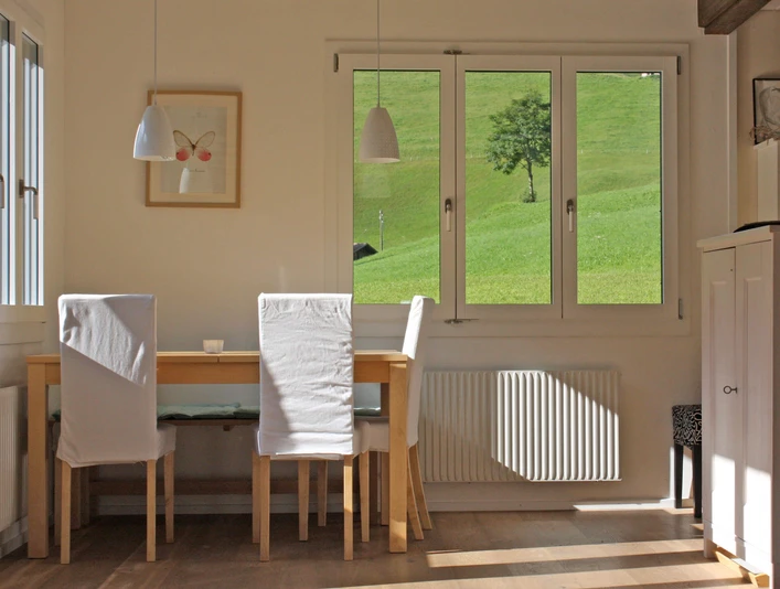 Dining area of the holiday apartment Hölzerner Esstisch mit weissen StühlenWooden dining table with white chairsTable de salle à manger en bois avec chaises blanches