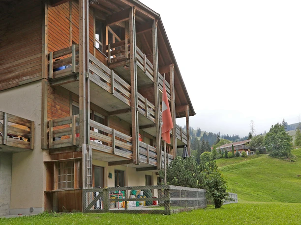 Mehrfamilienhaus mit Holzfassade und Balkonen
