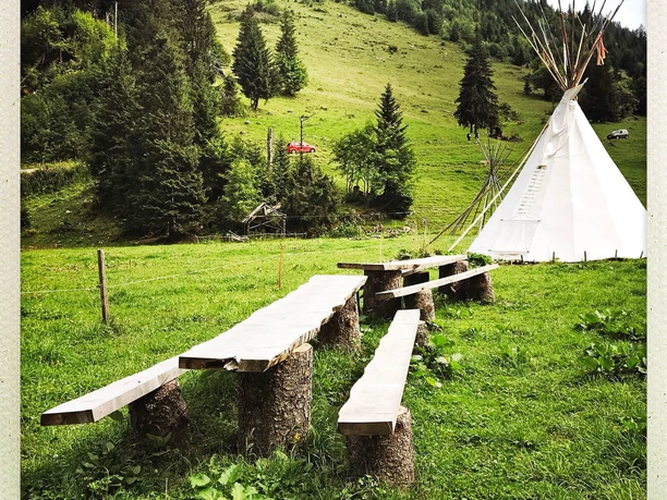 Tische und Bänke im Tipi-Dorf