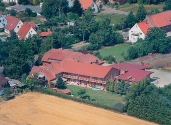 Ferienhof Meyer Luftbild Luftbildaufnahme eines großzügigen Ferienhofs mit roten Dächern, umgeben von ländlicher Umgebung.