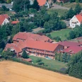 Ferienhof Meyer Luftbild Luftbildaufnahme eines großzügigen Ferienhofs mit roten Dächern, umgeben von ländlicher Umgebung.