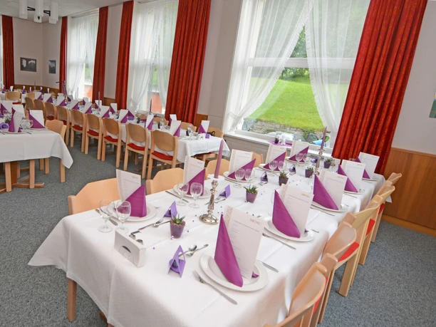 Der Saal im Hotel Kurhaus Grimmialp für Fest gedeckt Lange Tischreihen festlich eingedeckt