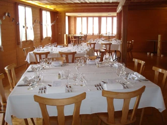 Saal des Gasthofs Rothbad Gedeckte Tische mit weissen Tischtüchern und Servietten