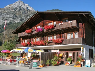 Spillgerten Hotel in Schwenden Grimmialp in summer Chalet-style restaurant with geraniums and parasols