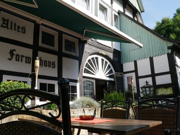 Ein restauriertes Fachwerkhaus mit Außenterrasse und traditionellem Stil in ländlicher Umgebung.