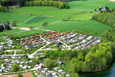 Campingplatz Beverblick Luftaufnahme eines gepflegten Campingplatzes inmitten grüner Wiesen und umgebung durchwachsener Wälder.