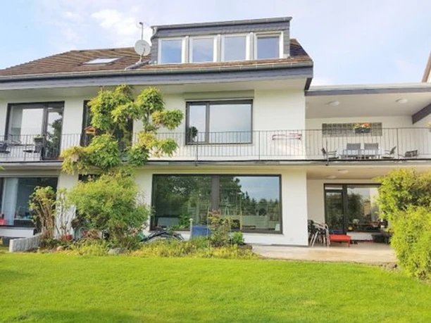 Ferienwohnung "Bergisches Land" Modernes zweistöckiges Haus mit weißer Fassade, großen Fenstern und gepflegtem Garten im Vordergrund.