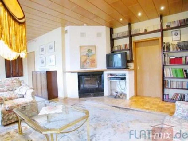 Wohnzimmer Wohnzimmer im Retro-Stil mit Kamin, Bücherregalen, einem Fernseher und gemütlichen Polstermöbeln.