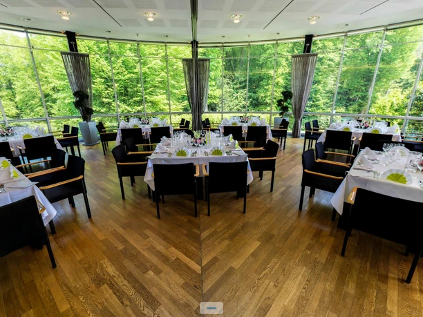 GENO Hotel - Bankett Ein stilvolles Restaurant mit eleganter Dekoration, großen Fenstern und Blick auf grüne Natur.