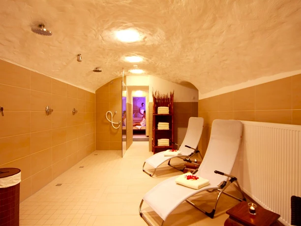 Sauna Wellnessbereich mit Liegestühlen, Handtüchern und gedämpften Lichtern für entspannendes Ambiente.