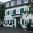 Aussenansicht Historisches Gasthaus mit grünen Fensterläden, weißen Blumenkästen und einem einladenden Eingang.