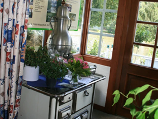 Landgasthof Tönnes Alte, dekorative Küchenzeile mit Pflanzen im Wintergarten einer traditionell eingerichteten Stube.