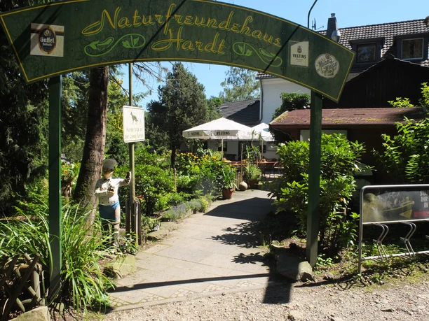 Haus Hardt Eingangsbereich des Naturfreundehauses Hardt mit grüner Bogenbeschriftung und einladender Terrasse.