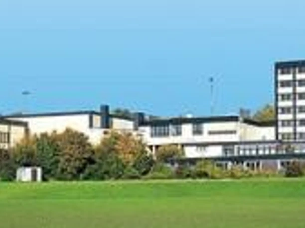 Rheinische Landesturnschule Breites Gebäudeensemble mit mehreren Etagen im Grünen, umgeben von Bäumen und Sportplatz.