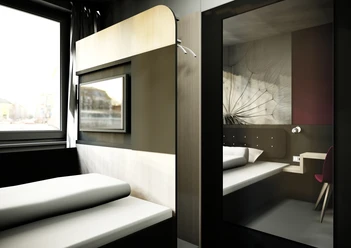 SMARTY Leichlingen-Cologne - Zimmer Modernes Hotelzimmer mit minimalistischer Einrichtung, großem Fenster, Bett und Schreibtisch.