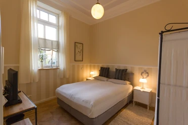 Villa Ruth - Wohnung 6 Schlafzimmer Helles, gemütliches Schlafzimmer mit Doppelbett, Nachttischen, Fenster und dezenten Dekorationen.