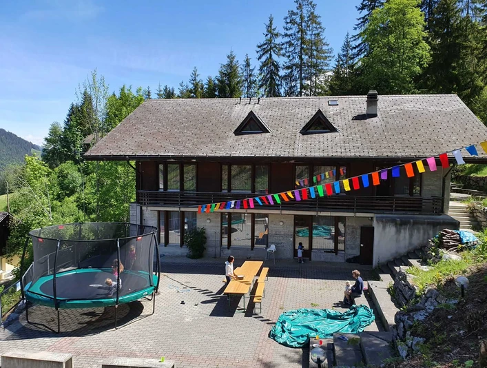 Exterior view of holiday home Edelweiss Hölzernes Gruppenhaus von Aussen, davor hängt eine TibetfahneWooden group house from the outside, with a Tibetan flag hanging in front of itMaison de groupe en bois vue de l'extérieur, devant laquelle est accroché un drapeau tibétain