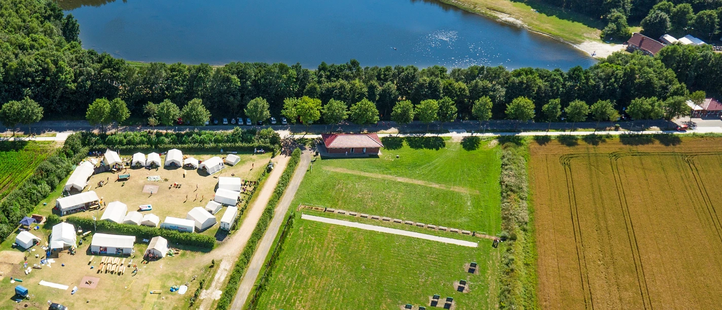 erikasee-esterwegen-2013_08_01_dsc2785-2 Zeltplatz mit Gruppenbereich und Wiesen am Erikasee, umgeben von Feldern und Wald im Sommer.