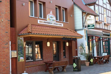 Mexican restaurant with wooden façade, red tiled roof, wooden benches and terrace in a half-timbered building.
